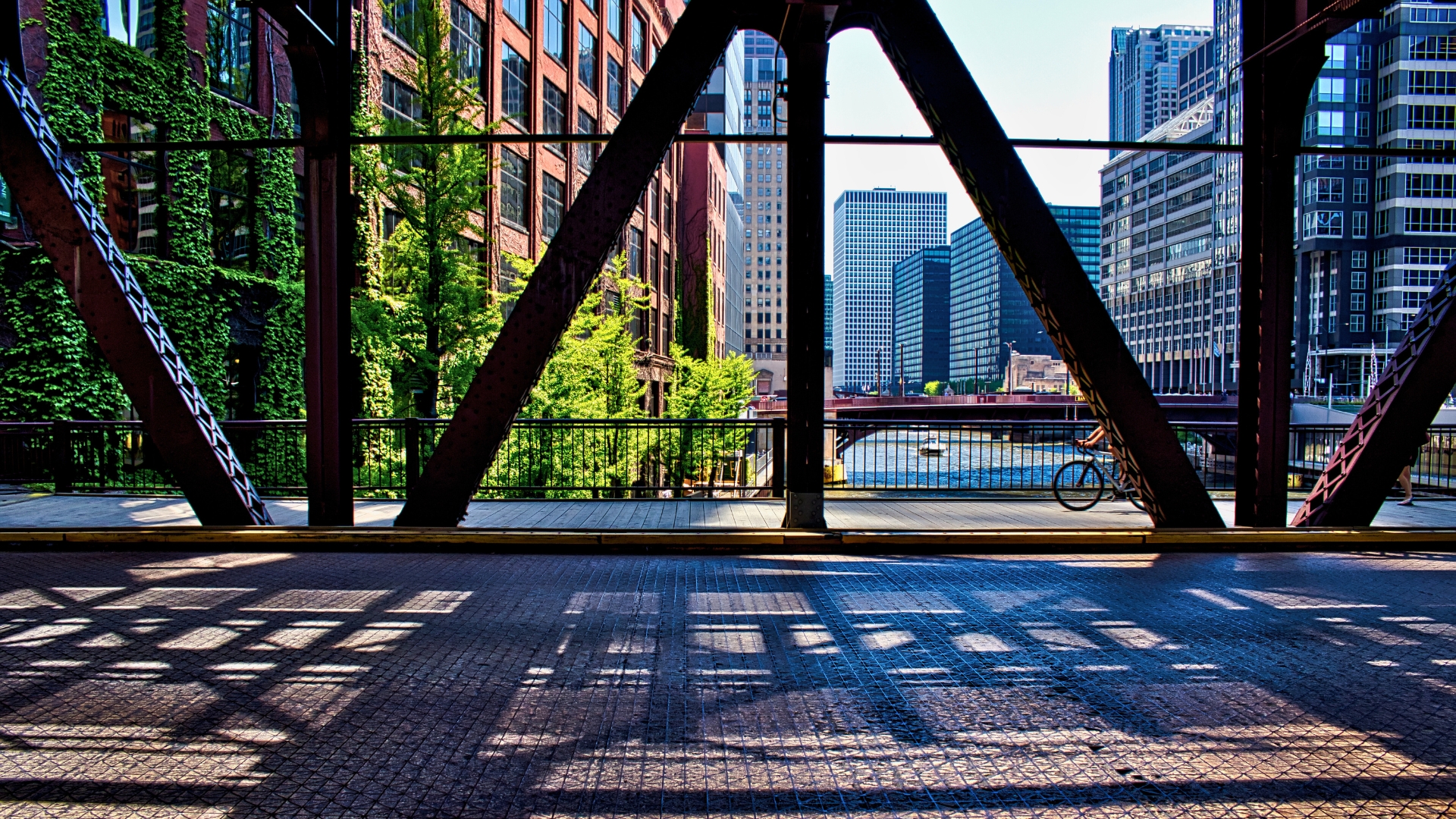 Bicyclist on Chicago's Lake Street underneath the shadows of the _el_ bridge over Chicago River