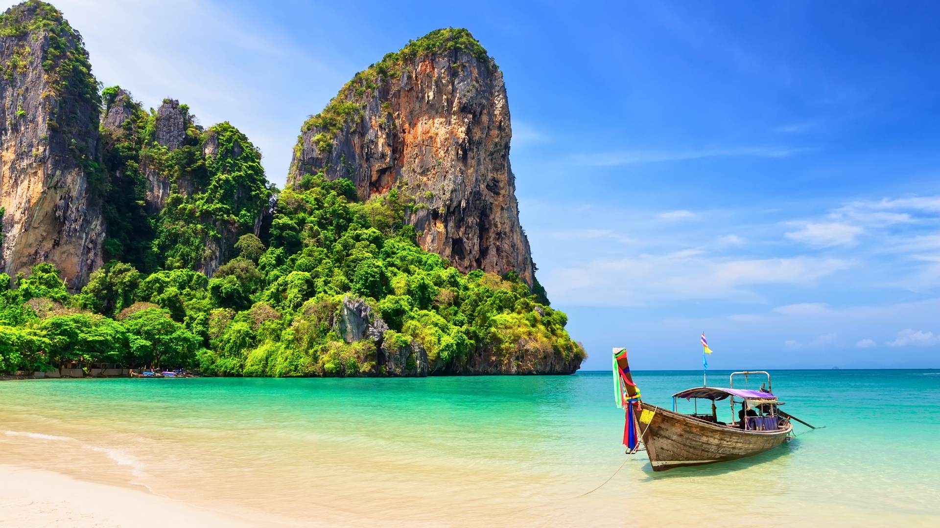 Thai traditional wooden longtail boat and beautiful sand beach